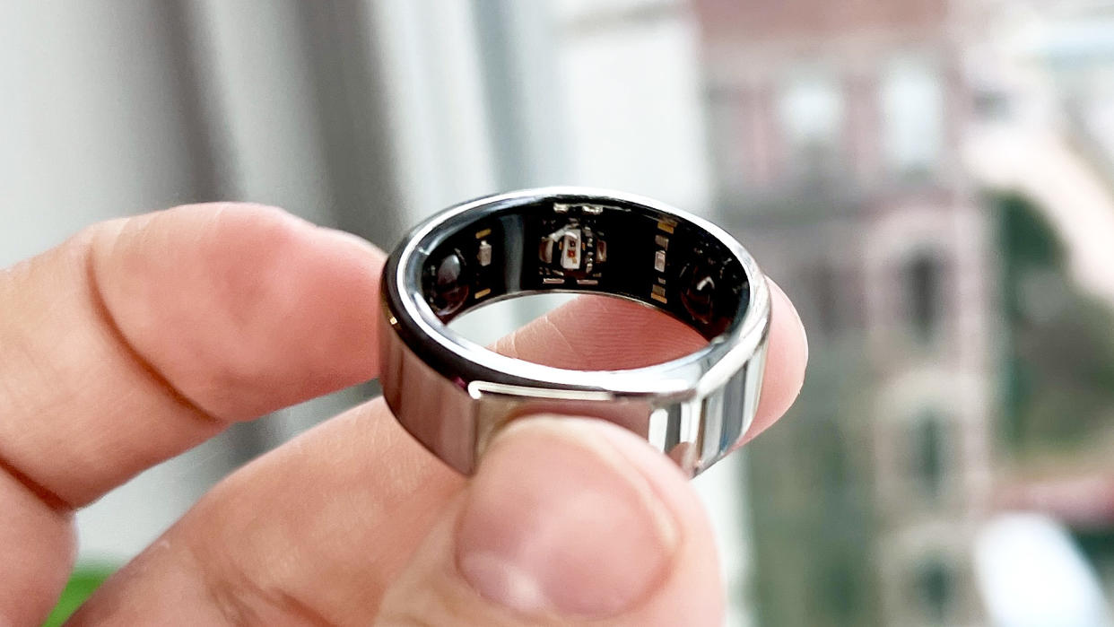  Oura Ring Gen 3 smart ring held between a person's fingers. 