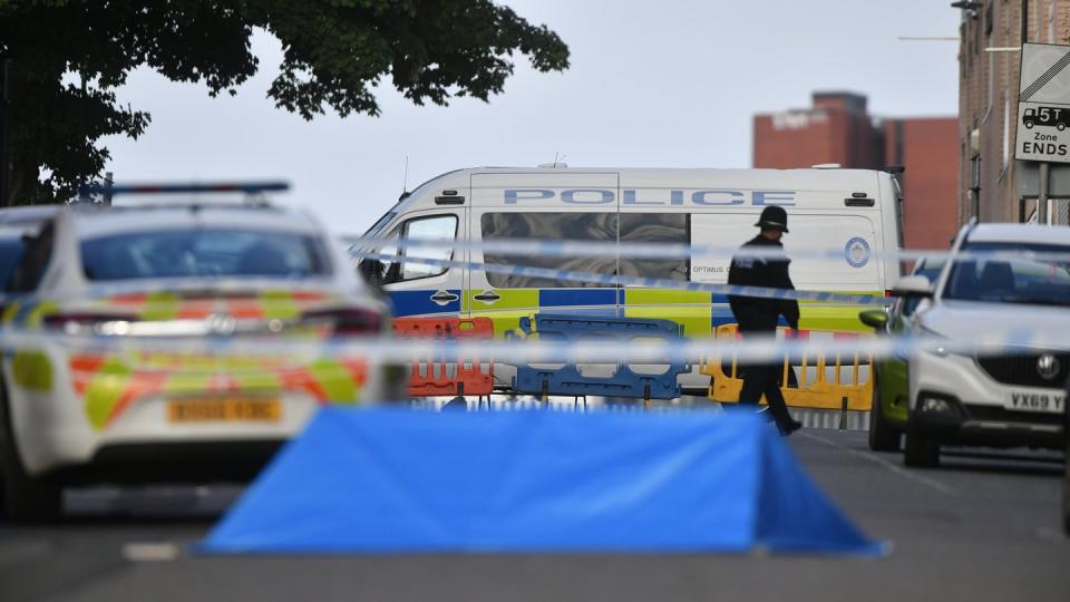 Ein Polizist und Fahrzeuge der Polizei stehen an einer Absperrung in der Irving Street in Birmingham.