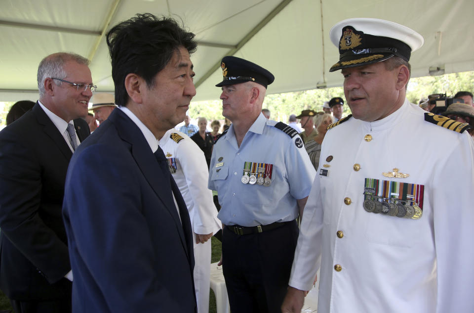 Japan's Prime Minister Shinzo Abe, second left, meets with Australian defense force personnel along with Australian Prime Minister Scott Morrison, left, after laying wreaths at the Cenotaph War Memorial in Darwin, Friday, Nov. 16, 2018. Abe is on a two-day visit to Australia. (AP Photo/Rick Rycroft, Pool)