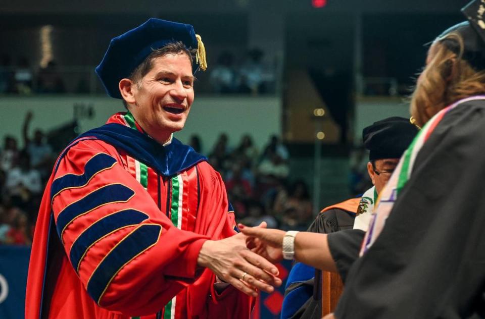 El presidente de Fresno State, Saúl Jiménez-Sandoval, estrecha la mano de los graduados durante la 47ª celebración anual de la graduación chicana/latina de Fresno State en el Save Mart Center, el sábado 20 de mayo de 2023.