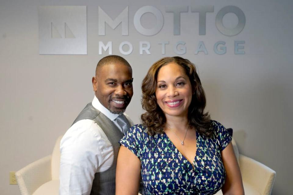 The husband and wife team of Kelly Jackson, left, and Davina Arceneaux sit for a portrait at their Motto Mortgage office Thursday, July 28, 2022, in Oakbrook Terrace, Ill. (AP Photo/Charles Rex Arbogast)