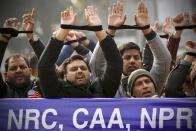 Indians raise their tied hands and shout slogans during a protest against the Citizenship Amendment Act in New Delhi, India, Friday, Dec. 27, 2019. Tens of thousands of protesters have taken to India's streets to call for the revocation of the law, which critics say is the latest effort by Narendra Modi's government to marginalize the country's 200 million Muslims. (AP Photo/Manish Swarup)