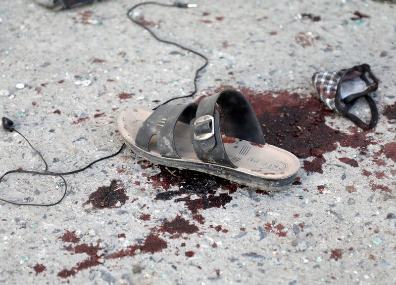 A sandal and bloodstain are seen near a bus which carried employees of an Afghan television station and was bombed, in Kabul