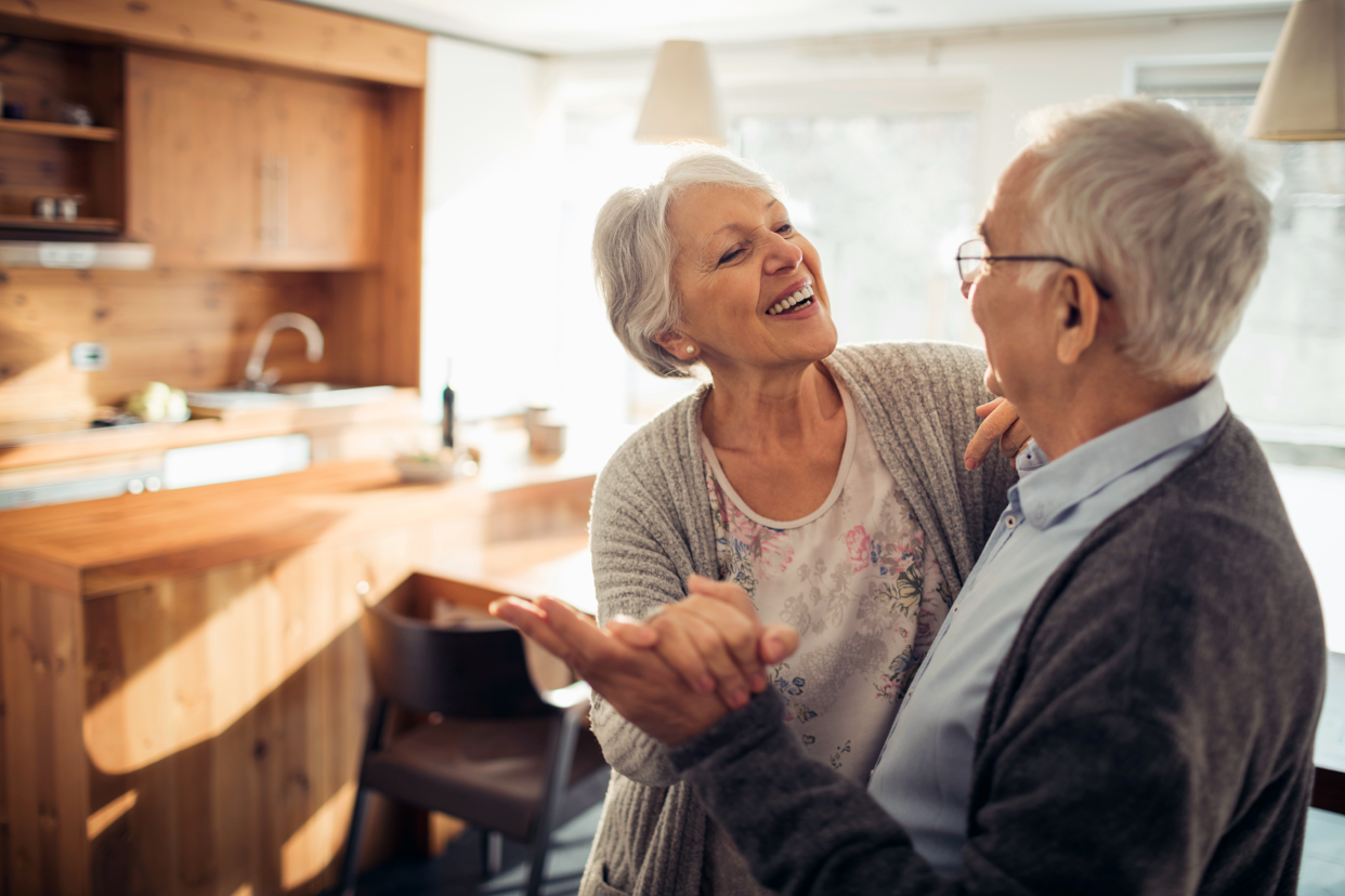 Senior couple dancing in their home