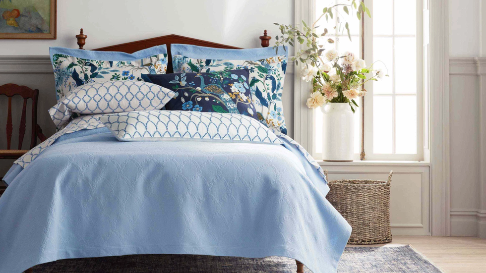 a bed with a blue and white comforter