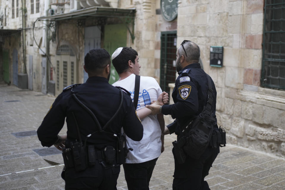 Israeli police officers detain an Israeli youth after his group was chanting slogans at the entrance to the Al Aqsa Mosque compound during a march in Jerusalem's Old City, Thursday, May 18, 2023. The parade was marking Jerusalem Day, an Israeli holiday celebrating the capture of east Jerusalem in the 1967 Mideast war. Palestinians see the march as a provocation. (AP Photo/Maya Alleruzzo)