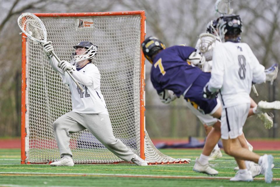Moses Brown goalie Cole Wilson makes a save off a shot from Barrington's Colin Hope as Hope gets drilled by a Quaker defenseman at the end of the second quarter of Friday's Division I matchup.