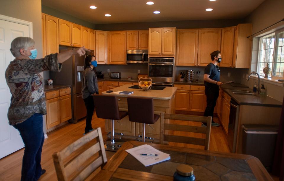 Real estate agent Leila Russell shows a couple from Los Angeles a house that was just placed on the market for $715,000 during an open house in Fort Collins, Colo. on Saturday, May 8, 2021. Within hours, the sellers already received at least one offer.