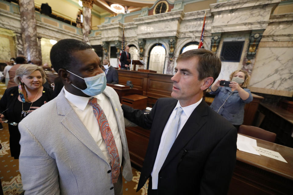 Sen. Briggs Hopson, R-Vicksburg, right, confers with Sen. Juan Barnett, D-Heidelberg, after the Senate voted to change the Mississippi state flag Sunday, June 28, 2020, at the Capitol in Jackson, Miss. Hopson presented the bill to the body. Both chambers of the Mississippi Legislature passed the bill to take down the state flag, which contains the Confederate battle emblem. Gov. Tate Reeves has already said he would sign whatever flag bill the Legislature decides on. (AP Photo/Rogelio V. Solis)