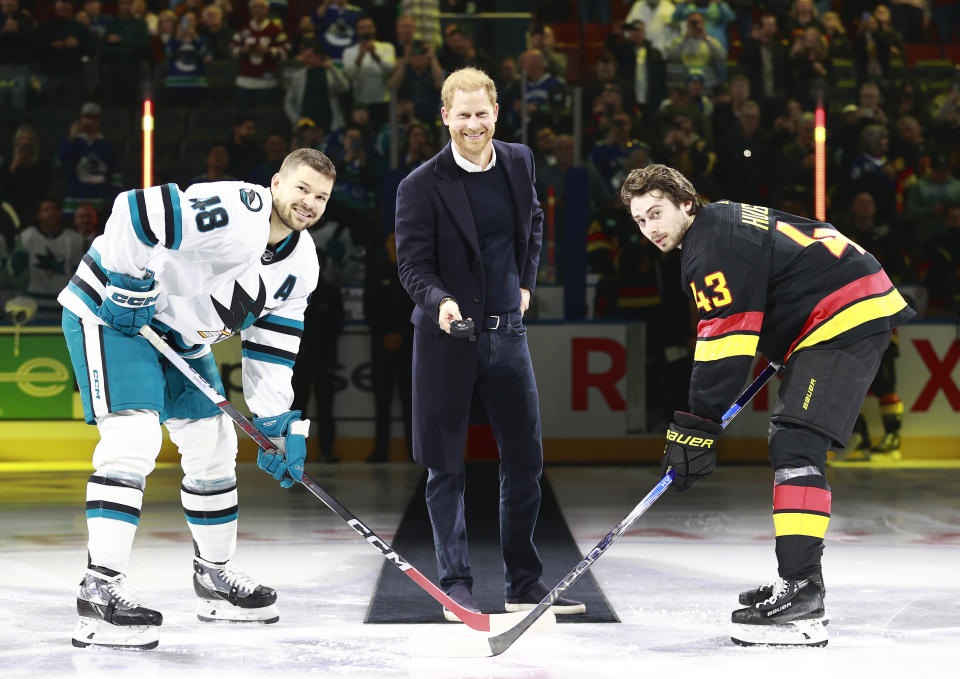 Gleich wirft Prince Harry den Puck zwischen die Eishockeyspieler Tomáš Hertl (links) und Quinn Hughes.