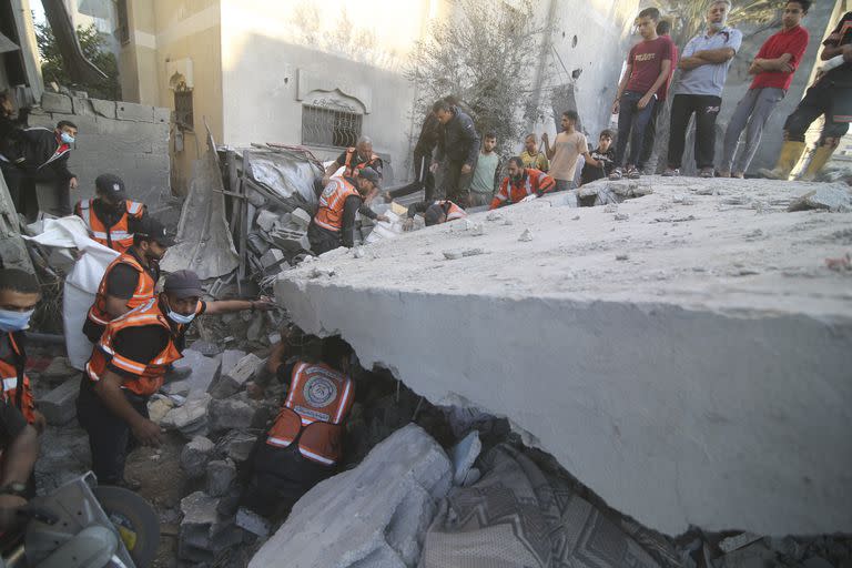 Palestinos buscan sobrevivientes entre los escombros del edificio de la familia Zanon, el cual fue destruido por ataques aéreos israelíes, el sábado 14 de octubre de 2023, en Rafah, Franja de Gaza. (AP Foto/Hatem Ali)