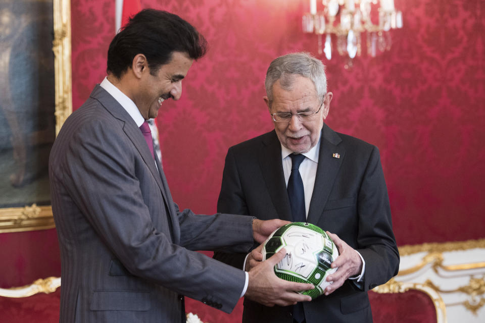 Austrian President Alexander Van der Bellen, right, hands over a football referring to the 2022 FIFA World Cup in Qatar to Qatar's Emir Sheikh Tamim bin Hamad Al Thani, left, prior to their meeting in Vienna, Austria, Tuesday, Mar. 5, 2019. (AP Photo/Michael Gruber)