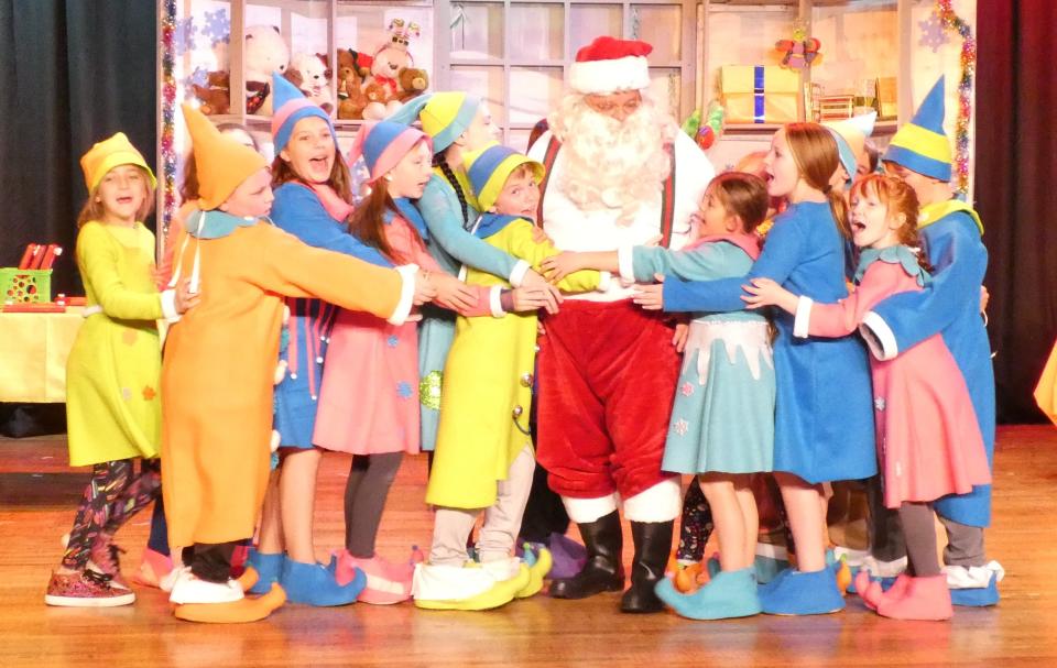 Santa Claus, played by Chris Stewart, gets a big hug from all his elves during a rehearsal of Bucyrus Little Theatre’s production of “Elf: The Musical” on Monday evening. The show opens Friday.