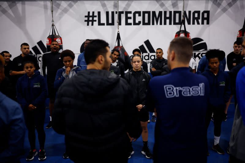 La boxeadora brasileña Beatriz Ferreira junto al equipo de boxeo mientras escuchan las indicaciones del entrenador al comienzo de su última sesión de entrenamiento antes de viajar a Europa, de cara a los Juegos Olímpicos de París 2024, en el centro de entrenamiento de la Federación Brasileña de Boxeo en Sao Paulo, Brasil