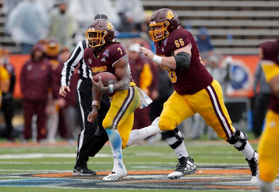 Central Michigan running back Lew Nichols (7) carries the ball escorted by offensive lineman Tyden Ferris (66) during the second half of the Sun Bowl against Washington State in El Paso, Texas, Friday, Dec. 31, 2021. Central Michigan won 24-21.