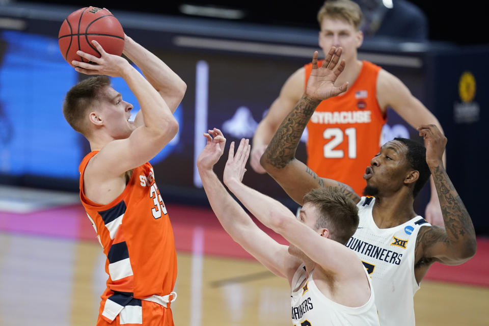 Syracuse's Buddy Boeheim (35) shoots over West Virginia's Sean McNeil (22) and Gabe Osabuohien (3) during the second half of a second-round game in the NCAA men's college basketball tournament at Bankers Life Fieldhouse, Sunday, March 21, 2021, in Indianapolis. Syracuse defeated Syracuse 75-72. (AP Photo/Darron Cummings)