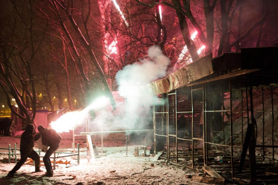 FILE In this file photo taken on Tuesday, Jan. 21, 2014, Protesters use fireworks during clashes with police in central Kiev, Ukraine. The mass protests in Kiev, the capital, erupted after Ukrainian President Viktor Yanukovych spurned a pact with the European Union in favor of close ties with Russia, which offered him a $15 billion bailout. (AP Photo/Evgeny Feldman, file)