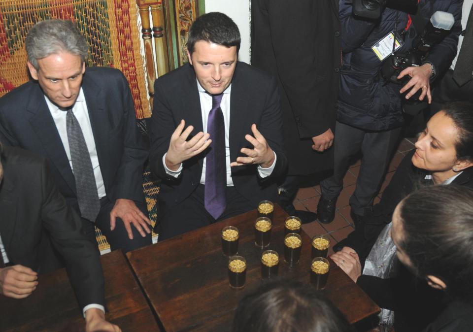 Italian Premier, Matteo Renzi , center, gestures as he shares a glass of tea with pine nuts during a meeting with members of the Tunisian civil society at the cafe des Nattes in Sidi Bou Said, north of the Tunisian capital Tunis, Tuesday, March 4, 2014. Earlier in the day Renzi had met the Tunisian President, Moncef Marzouki, and his Tunisian counterpart, Mehdi Jomaa. (AP Photo/Hamadi Ben Taieb)