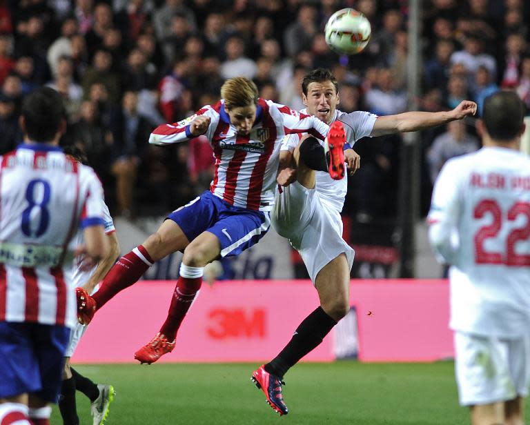 Atletico Madrid's forward Fernando Torres (L) vies with Sevilla's midfielder Grzegorz Krychowiak (R) during the Spanish league football match in Sevilla on March 1, 2015