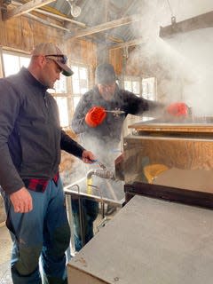 Galen Parke and his father, Adam, work in a steam-filled sugarhouse to make maple syrup on the family's Windswept Farm in Barton, Vt.