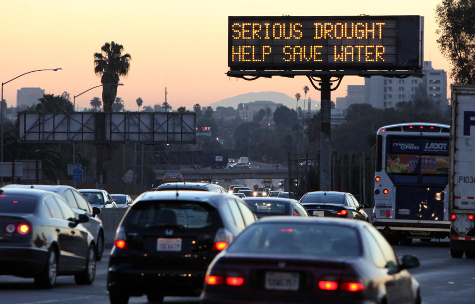 FILE - In this Friday, Feb. 14, 2014, file photo, morning traffic makes it's way toward downtown Los Angeles along the Hollywood Freeway past an electronic sign warning of severe drought. As of Wednesday, April 30, 2014, Pensacola, Florida, got more rain in one stormy day than drought-struck Los Angeles has had in more than two years. (AP Photo/Richard Vogel, File)