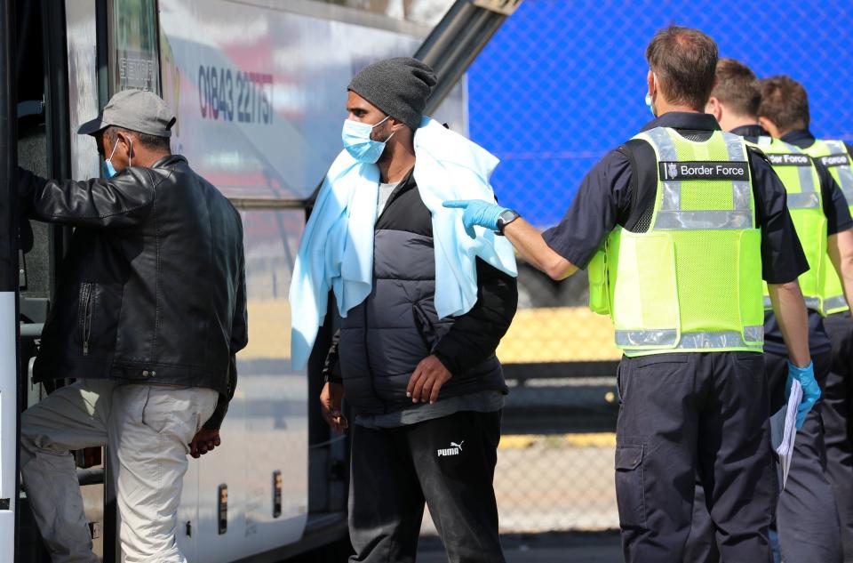 Men thought to be migrants boarding a bus (PA)