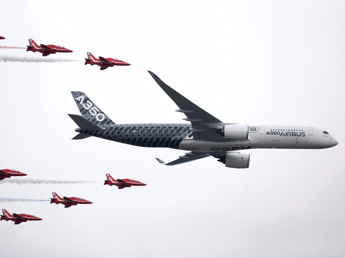 An Airbus A350 aircraft flies in formation with Britain's Red Arrows flying display team at the Farnborough International Airshow in Farnborough, Britain July 15, 2016.  REUTERS/Peter Nicholls