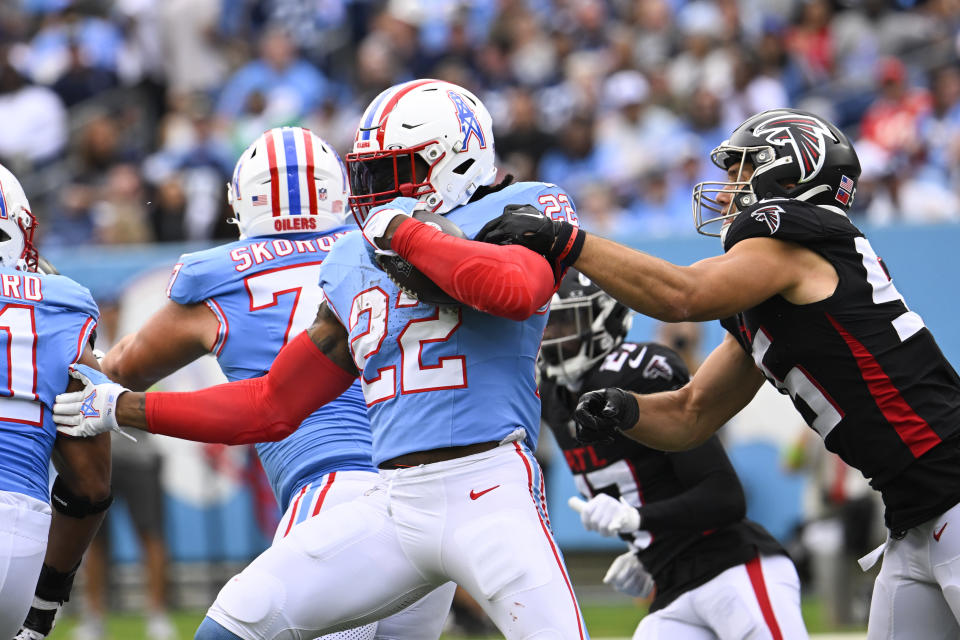 Tennessee Titans running back Derrick Henry (22) is grabbed by Atlanta Falcons linebacker Kaden Elliss (55) during the second half of an NFL football game, Sunday, Oct. 29, 2023, in Nashville, Tenn. (AP Photo/John Amis)