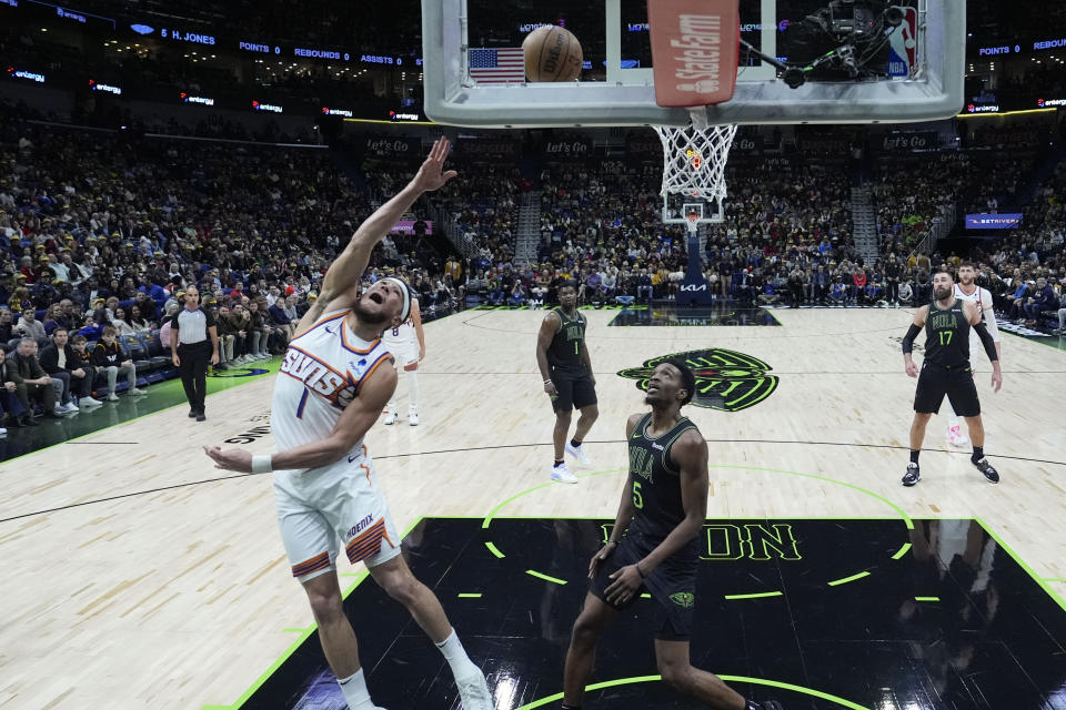 Phoenix Suns guard Devin Booker (1) goes to the basket over New Orleans Pelicans forward Herbert Jones (5) in the first half of an NBA basketball game in New Orleans, Friday, Jan. 19, 2024. (AP Photo/Gerald Herbert)