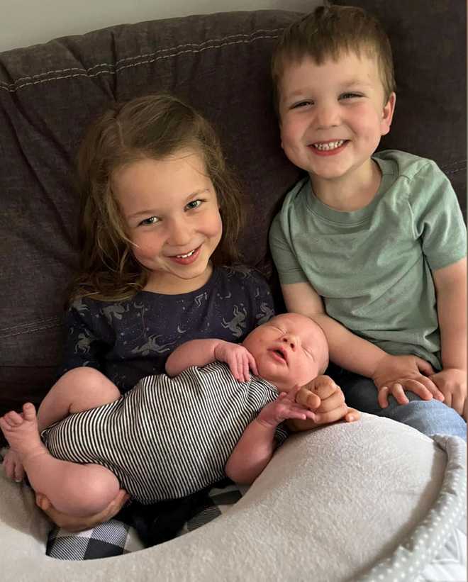 Cora Clancy holds her baby brother, Callan, while sitting next to her younger brother, Dawson.