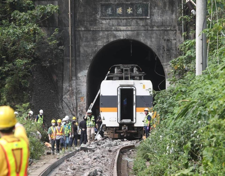 台鐵太魯閣號在花蓮撞上工程車出軌意外，現場工作人員開始吊起第二節車廂，放回正常的軌道慢慢與一號車廂連接後拖離現場。（鄭任南攝）