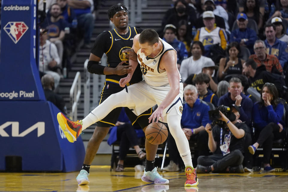 Denver Nuggets center Nikola Jokic, right, is defended by Golden State Warriors center Kevon Looney during the second half of Game 1 of an NBA basketball first-round playoff series in San Francisco, Saturday, April 16, 2022. (AP Photo/Jeff Chiu)