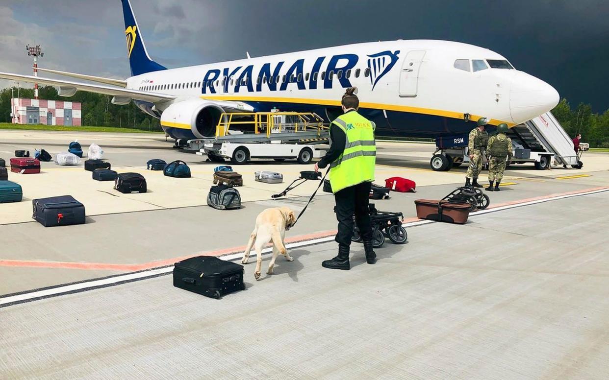 A security guard checks the luggage of passengers on the 'hijacked' Ryanair plane in Minsk - AP