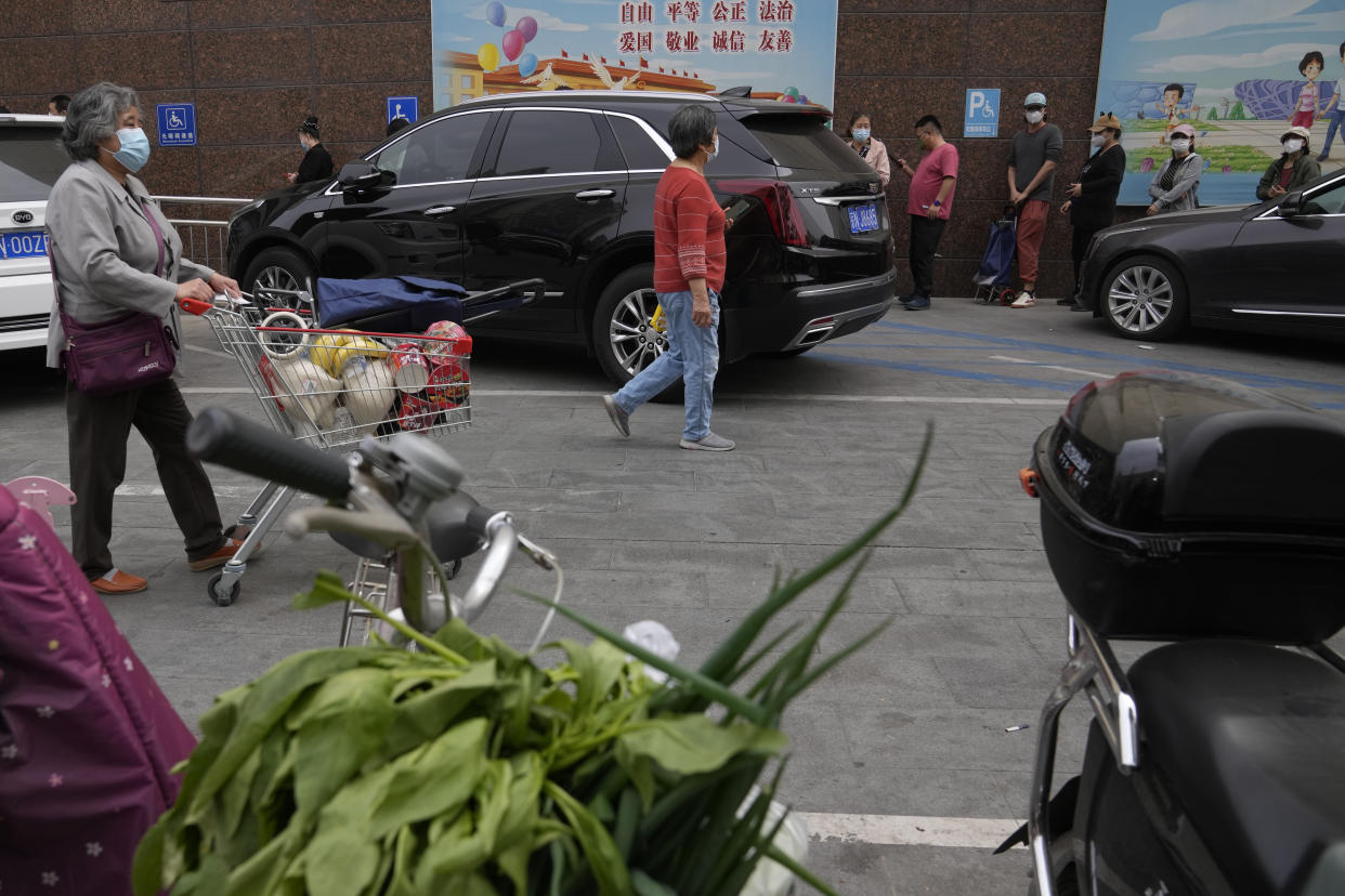 Residents wearing masks line up to enter a supermarket on Monday, April 25, 2022, in Beijing. (AP Photo/Ng Han Guan)