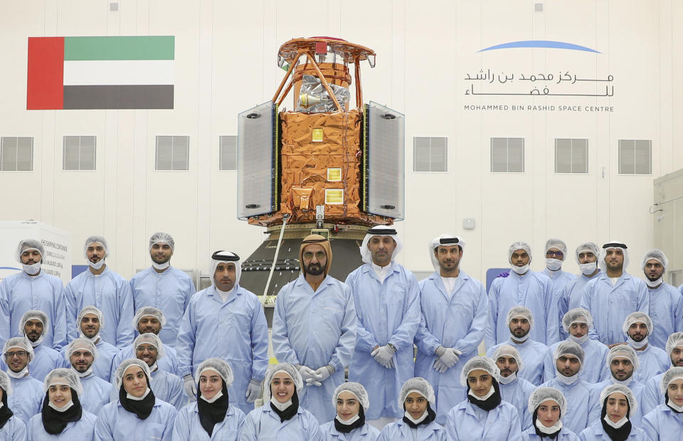 In this undated photograph released Feb. 2, 2018 by the state-run Emirates News Agency (WAM), Sheikh Mohammed bin Rashid Al Maktoum, Dubai's ruler and the vice president and prime minister of the United Arab Emirates, center back row, visits the Mohammed bin Rashid Space Center to see the locally made KhalifaSat satellite in Dubai, United Arab Emirates. A Japanese rocket carrying the United Arab Emirates' first locally-made satellite has successfully lifted off from a space center in southern Japan Monday, Oct. 29, 2018. (WAM via AP)