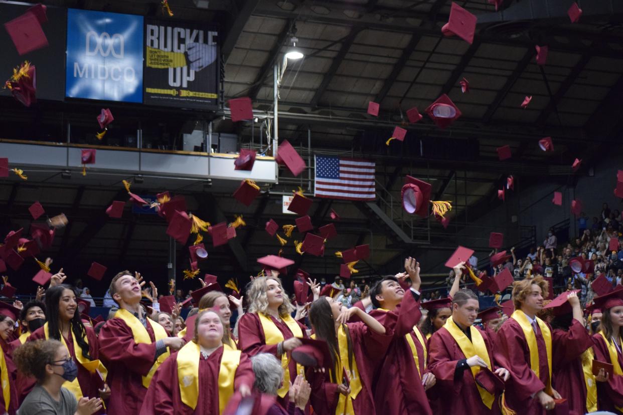 Roosevelt High School graduates toss their caps in the air after graduation on May 30, 2021.