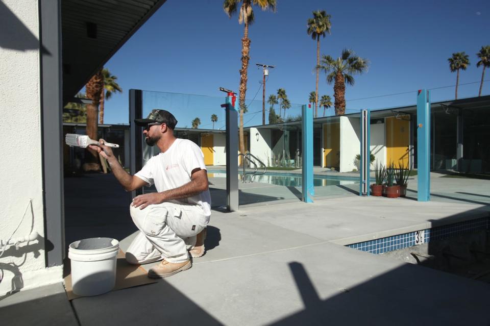 Candido Galeno of Glenn Strickland Painting applies a fresh coat of paint to the trim of the Limon property in preparation for Modernism Week in Palm Springs, Calif., on Thursday, Feb. 10, 2022.