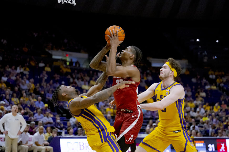 LSU guard Trae Hannibal (0) fouls Alabama forward Nick Pringle (23) during the first half of an NCAA college basketball game in Baton Rouge, La., Saturday, Feb. 10, 2024. (AP Photo/Matthew Hinton)