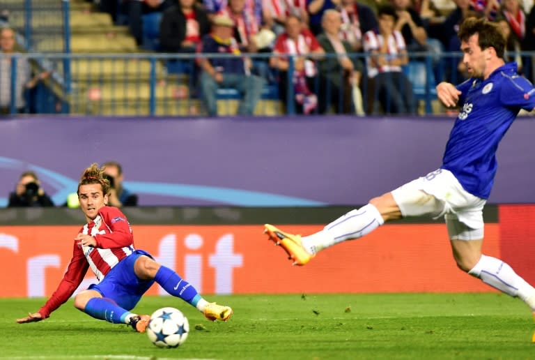 Atletico Madrid forward Antoine Griezmann (L) curls a cross in past Leicester City defender Christian Fuchs during the Champions League quarter-final first leg at the Vicente Calderon stadium in Madrid on April 12, 2017