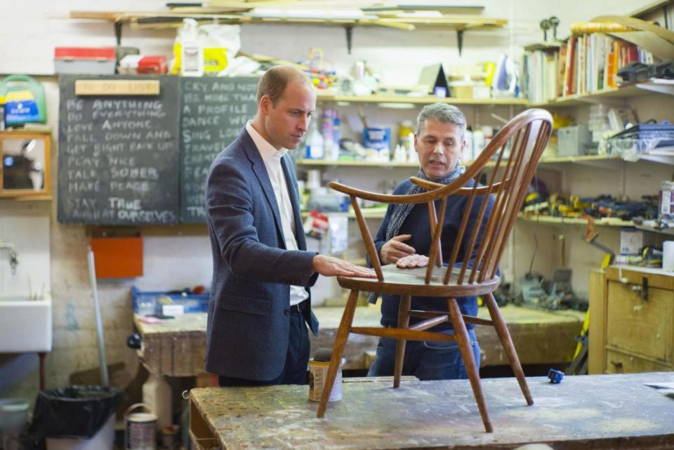 Prince William inspects a chair restored by a former-addict as part of the charity's therapeutic process (PA)