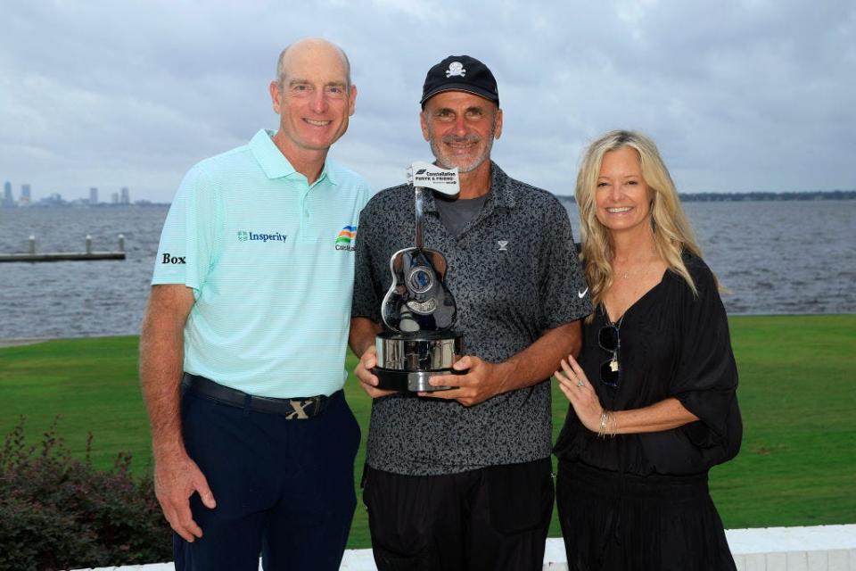 Rocco Mediate muestra su trofeo por ganar el evento Constellation Furyk & Friends PGA Tour Champions el 6 de octubre en el Timuquana Country Club. Con él están los anfitriones del torneo Jim y Tabitha Furyk.