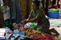 A family member takes care of a HIV patient at HIV/AIDS care center founded by Phyu Phyu Thin, a parliament member of Myanmar Opposition Leader Aung San Suu Kyi's National League for Democracy Party, in outskirts of Yangon, Myanmar, Saturday, Mar. 1, 2014. Doctors Without Borders said Friday it has been expelled from Myanmar and that tens of thousands of lives are at risk. The government defended the move Friday, accusing the organization of creating tensions and instability in violence-scarred Rakhine state, where it has faced repeated protests for treating members of the long-persecuted Rohingya Muslim minority. (AP Photo/Khin Maung Win)