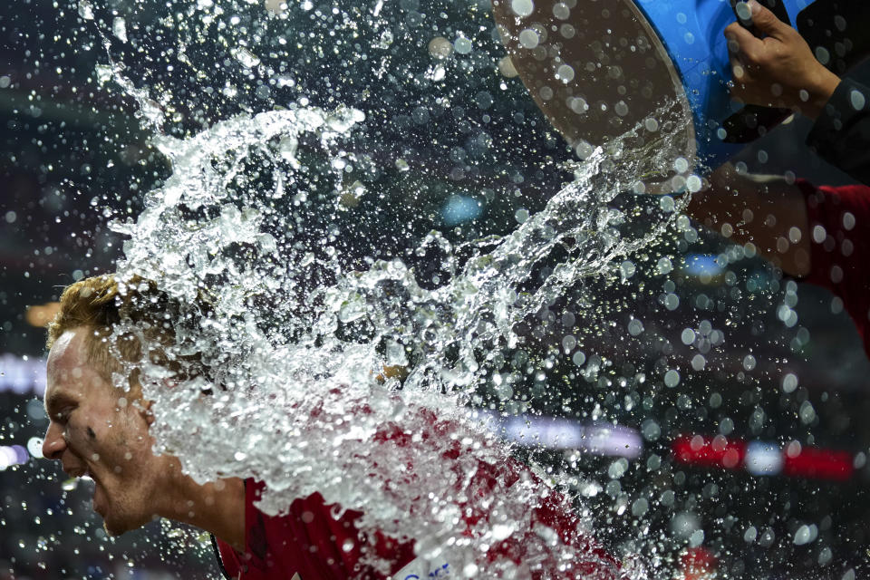 Cincinnati Reds' Matt McLain is doused by teammates after driving in the winning run against the Los Angeles Dodgers during the ninth inning of a baseball game in Cincinnati, Tuesday, June 6, 2023. (AP Photo/Aaron Doster)