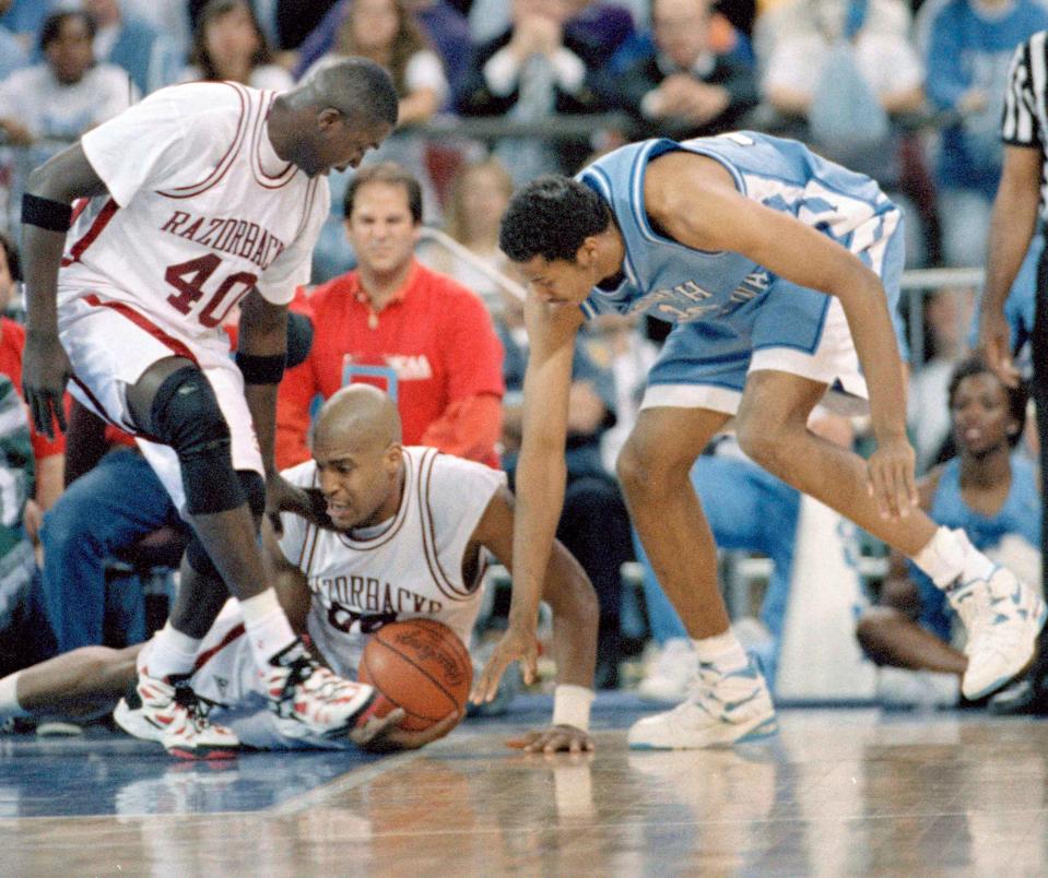 Arkansas' Elmer Martin, left, and Corliss Williamson, on floor, go for a loose ball with North Carolina's Rasheed Wallace during first half NCAA Final Four semi-final action at the Kingdome in Seattle, April 1, 1995. The winner faces UCLA Monday for the championship. (AP Photo/Eric Draper)