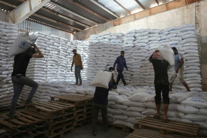 Stacking bags of UN aid at a warehouse near the Bab al-Hawa crossing before Tuesday's Russian veto (OMAR HAJ KADOUR)