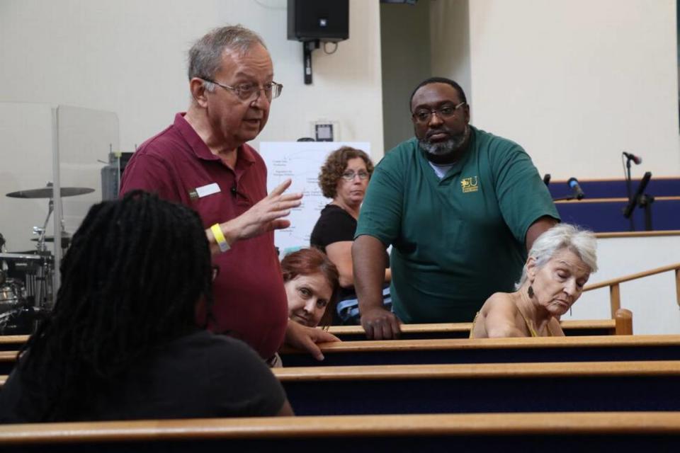 Walter Smith II (right) listens to community presenters at the Progress Village Environmental Health Fair at the Victory African Methodist Episcopal Church Saturday, April 22, 2023.