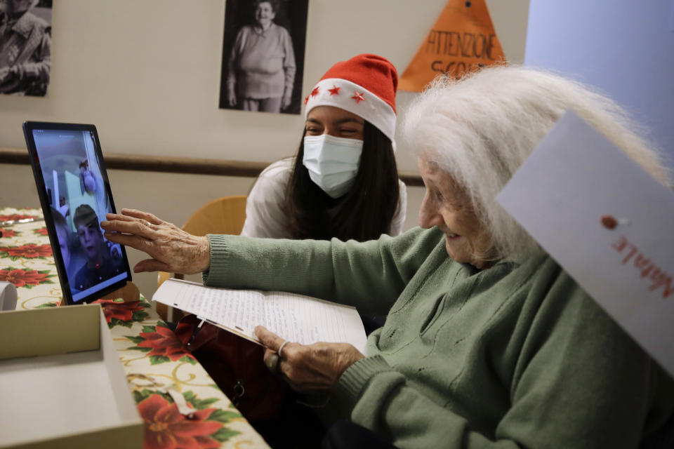 Rina Livoli, 101, gestures as she talks on a video call with a donor, unrelated to her, who bought and sent her a lottery ticket as Christmas present through an organization dubbed "Santa's Grandchildren", at the Martino Zanchi nursing home in Alzano Lombardo, one of the area that most suffered the first wave of COVID-19, in northern Italy, Saturday, Dec. 19, 2020. (AP Photo/Luca Bruno)