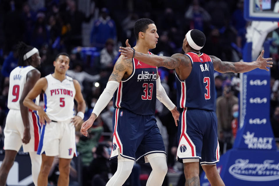 Washington Wizards forward Kyle Kuzma (33) is greeted by teammate guard Bradley Beal (3) after hitting a 3-point basket in the closing seconds during overtime of an NBA basketball game against the Detroit Pistons, Wednesday, Dec. 8, 2021, in Detroit. (AP Photo/Carlos Osorio)