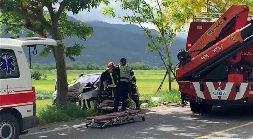 64歲吳姓婦人駕車撞路樹，車頭變形，警方消防人員到場救援。（圖／中國時報王志偉翻攝）