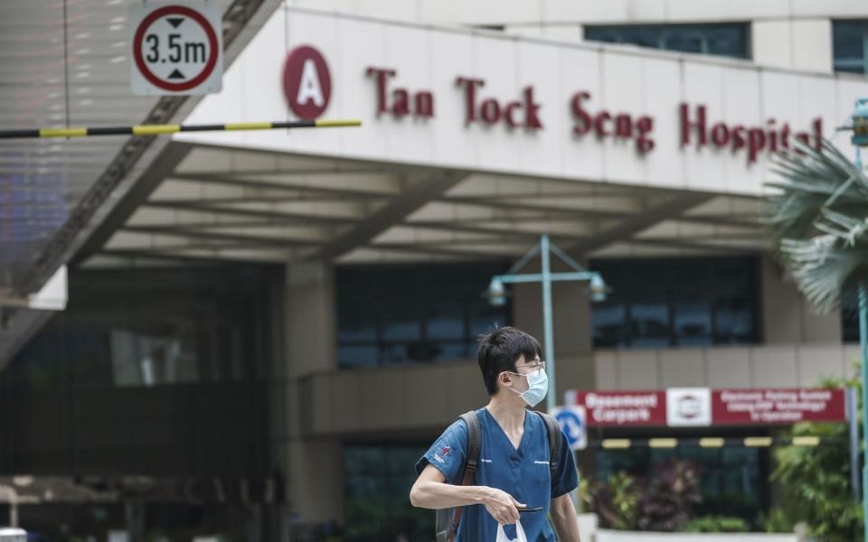 A medical personnel walks out from the lobby of the Tan Tock Seng Hospital in Singapore - WALLACE WOON/EPA-EFE/Shutterstock